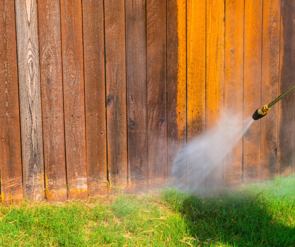Pressure washing a wooden fence of home garden